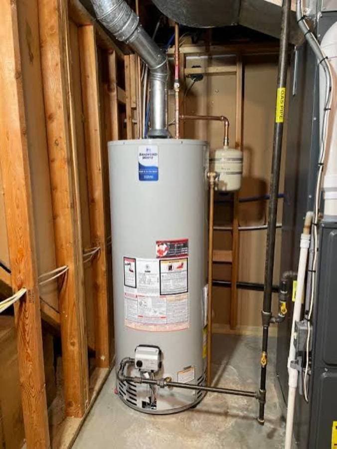 Installed residential water heater with connected copper piping and safety valves